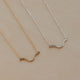 Two gold and silver necklaces on a beige background
