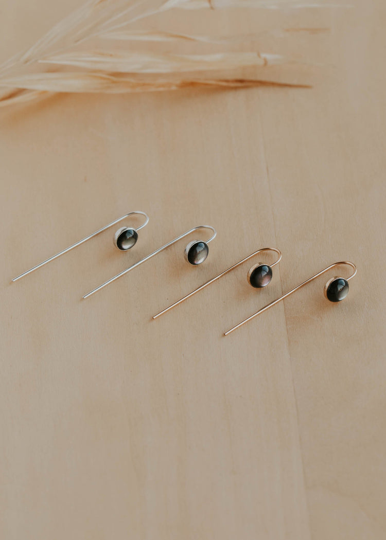 Set of three earrings on a beige background