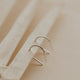 Sterling silver tiny horseshoe threader earrings by Hello Adorn on a wooden surface with neutral background