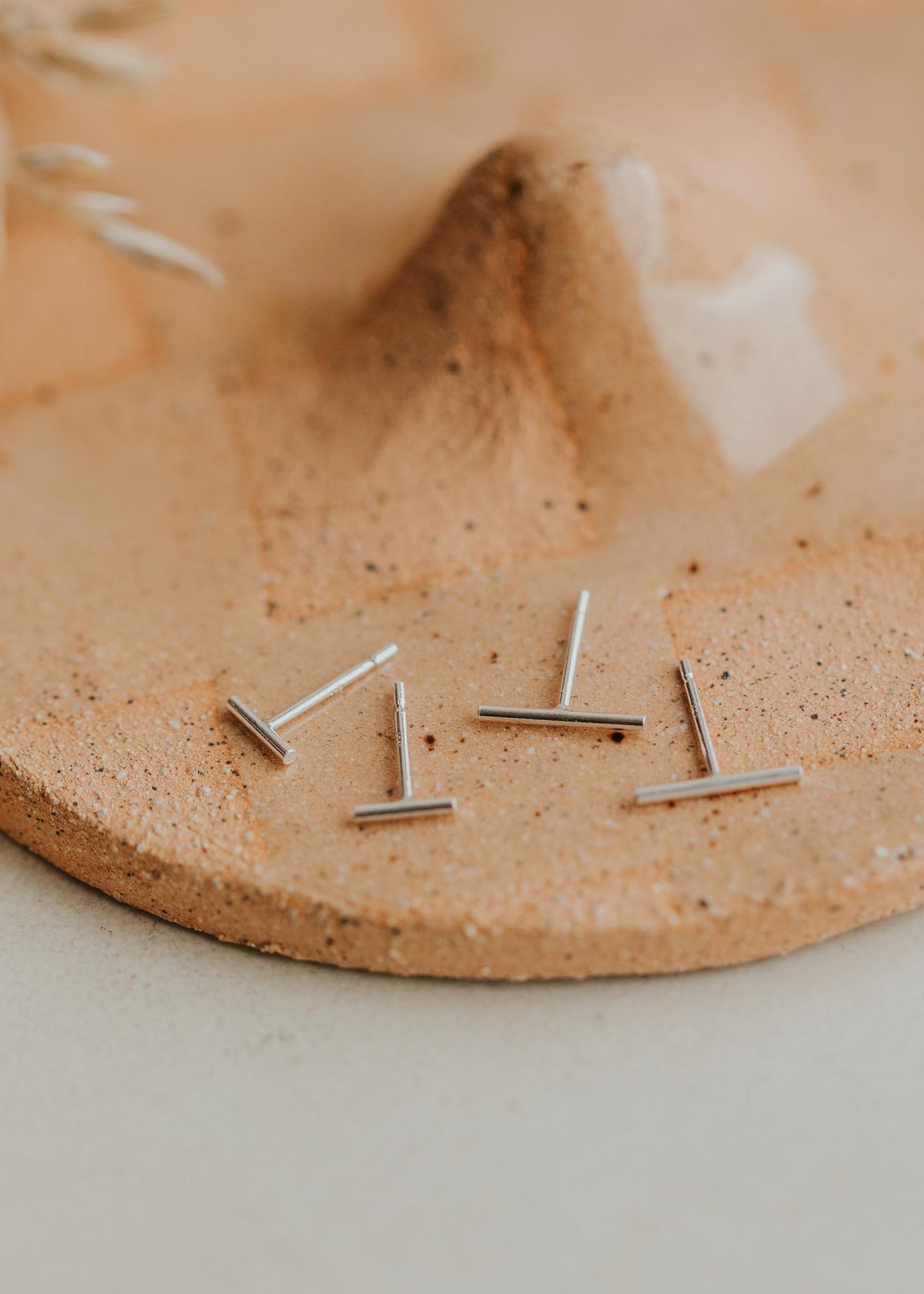 Sterling silver dainty earrings by Hello Adorn, bar stud earring style.