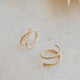14k gold fill tiny twist earrings by Hello Adorn on a cream surface with white star decoration