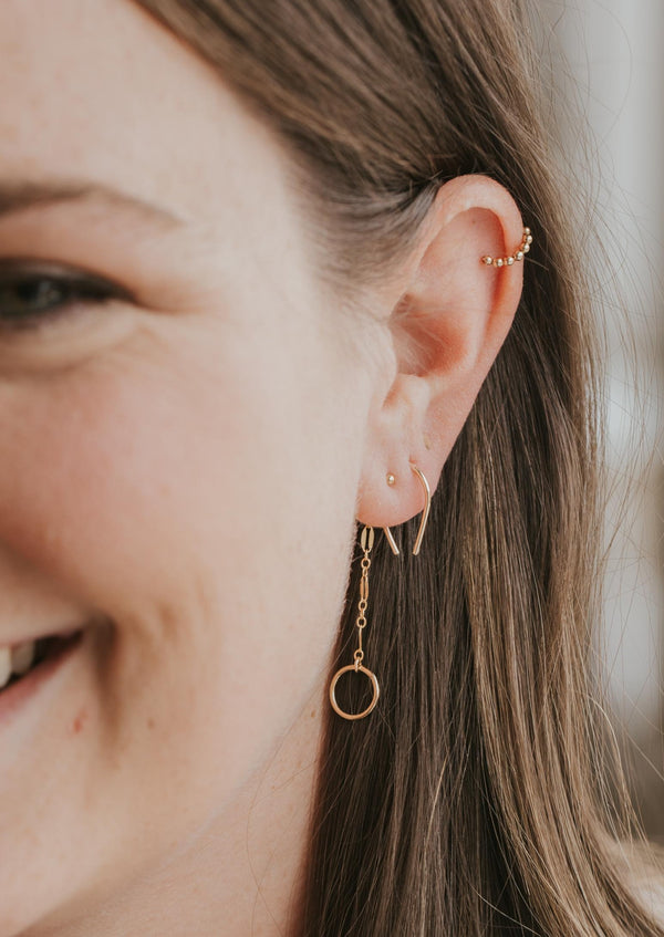 Tiny horseshoe threaded earrings by Hello Adorn styled with beaded gold ear cuff and backdrop earring.