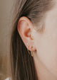 Earrings with hanging chain in Mini Annex Style by Hello Adorn styled with a horseshoe threader earring, gold circle dot stud, and a tiny hoop earring in 14k gold fill earrings.