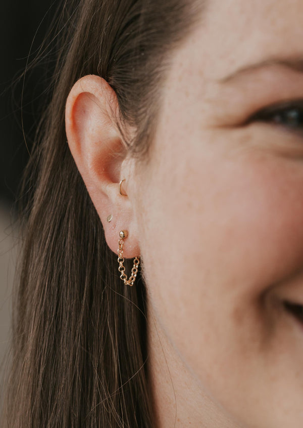 Earrings with hanging chain in Mini Annex Style by Hello Adorn styled with round gold studs and a tiny hoop gold earring all in 14k gold fill.