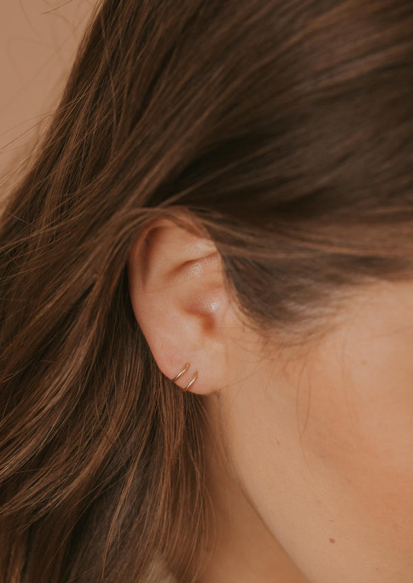Twist Earrings being shown in an ear by Hello Adorn.