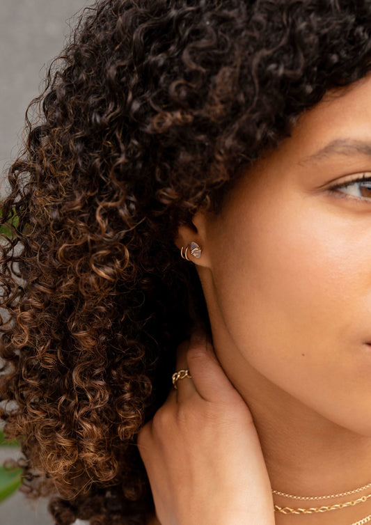 A gold jewelry idea featuring a necklace layering look paired with a chain ring, a Double Up Post earring, and a white stone earrings in the Marquise Moonstone Studs by Hello Adorn.