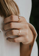 3 stack rings using an open ring in the sonder gold ring design, confetti textured ring, and an opal stone statement ring shown on a model in 14k gold fill by Hello Adorn.