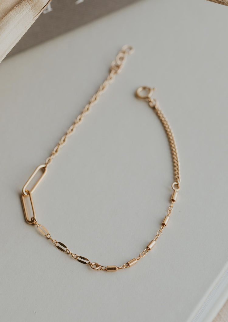 A gold chain bracelet with different types of chains for bracelets linked together to create a linked chain bracelet using 4-7 different chains created by Hello Adorn.