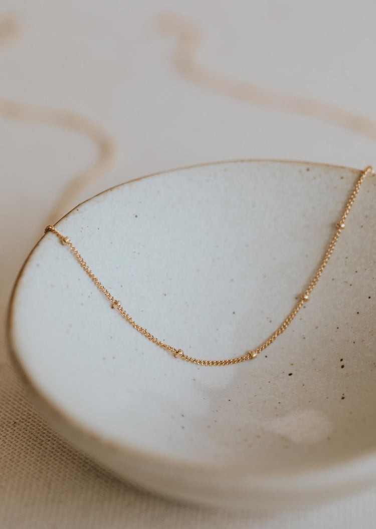 Delicate 14kt Gold Fill Curb chain with small beads spaced evenly apart.