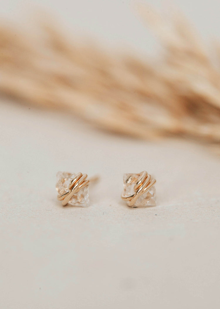 Handmade jewelry using herkimer diamonds shown close-up in 14k gold fill to create diamond quartz stud earrings by Hello Adorn.