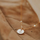 A custom necklace with a tiny circle charm hand-stamped with a symbol on a 14k gold fill chain necklace created by Hello Adorn.