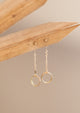 Drop earrings from Hello Adorn in the Monday Backdrop style where a stud earring is attached to a chain drop earring with a circle attached to the end of the chain.