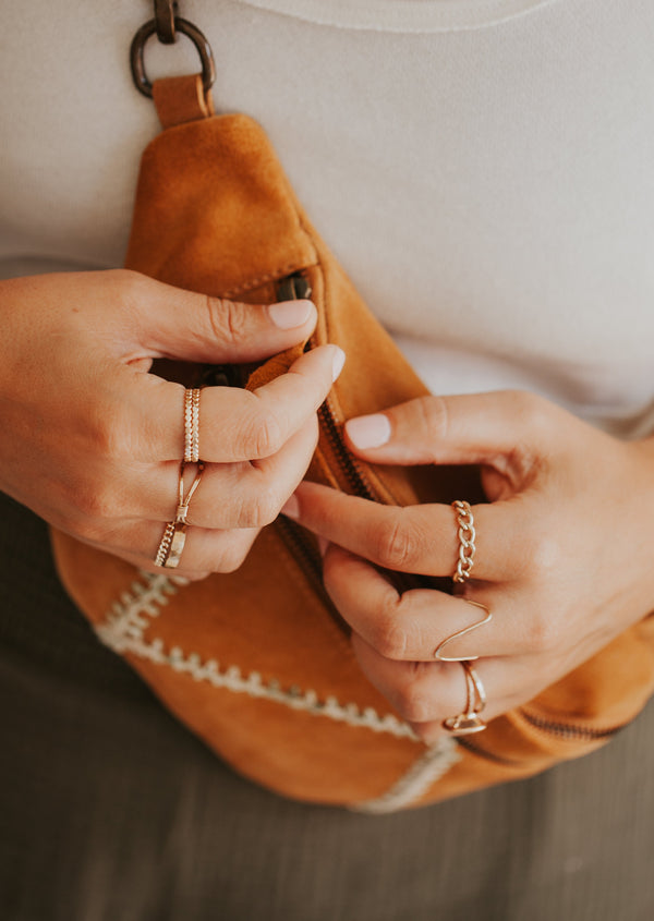 Stackable ring ideas by Hello Adorn, this stack features two hammered rings, a wire wrapped ring, a statement ring as a textured ring, a gold chain ring, a thick chain ring, a handmade ring that was hammered and shaped to create a wave ring, and other gold stacking rings.