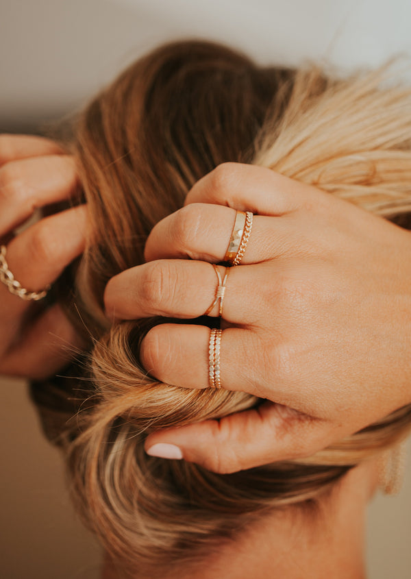 Ring stack styled with confetti band rings, wire wrapped cleo ring, chain ring, and hammered statement ring by Hello Adorn.