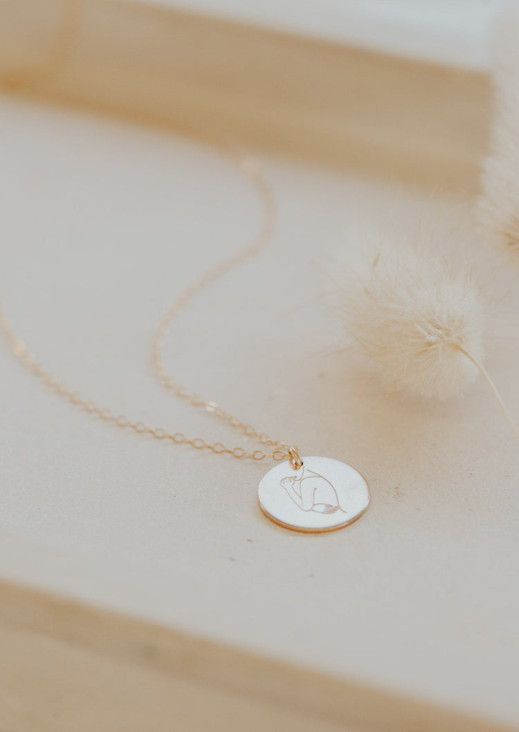 A 14kt Gold Fill round disc hand-stamped with a feminine silhouette drawing promoting body positivity.