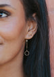 A circle crop earring created by Hello Adorn in the Monday Backdrop style, a pair of drop earrings paired with a simple stud earring.