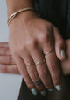 Learn how to stack rings on fingers with Hello Adorn with this 14k gold fill ring stack using two thin hammered rings, two thin ring bands, and a chain ring styled with a gold cuff bracelet.