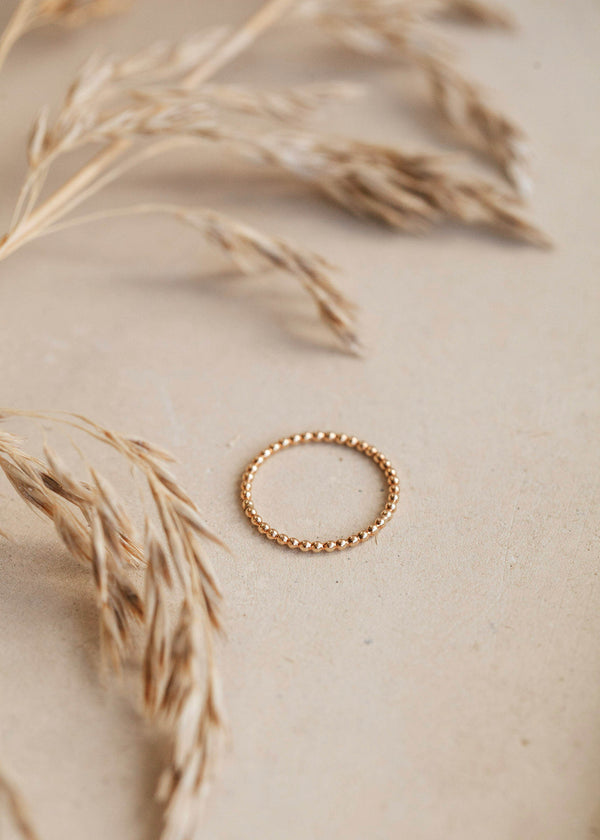 A textured ring handmade by Hello Adorn in the beaded ring style shown in 14k gold fill.