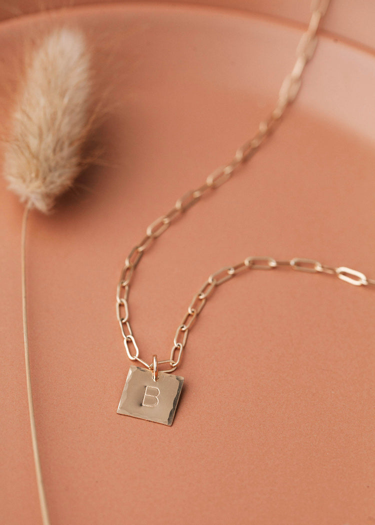 Square charm necklace with raw, hammered edges and stamped with your favorite initial in 14kt gold fill.