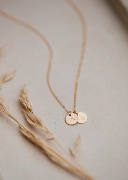 A custom necklace with a charm stamped with your personalized design by Hello Adorn to create a stamped necklace shown in 14k gold fill.