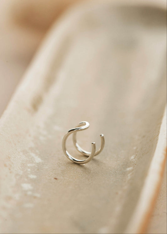 Sterling silver ear cuff lying flat on a jewelry tray by Hello Adorn.