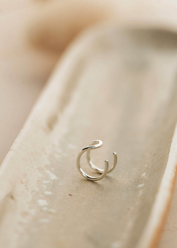 Sterling silver ear cuff lying flat on a jewelry tray by Hello Adorn.