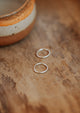 Sterling silver hoop earrings laying flat on a table by Hello Adorn.