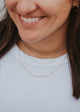 A three layer necklace look paired with a pair of gold hoop earrings, the necklace stack features a thick gold chain choker, a thin layered gold chain, and the Maeve Chain which is a linked chain necklace handmade by Hello Adorn.