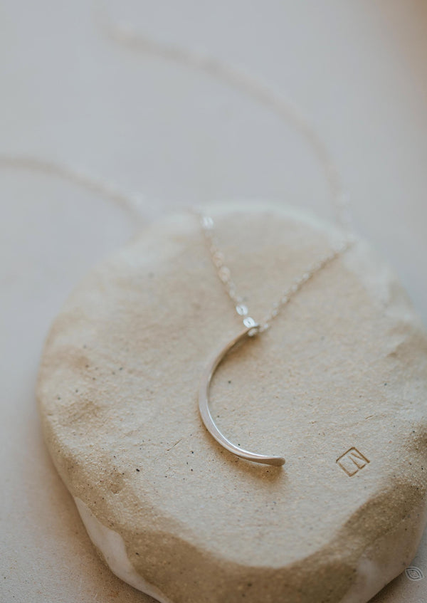 A silver statement necklace with a moon pendant handmade by Hello Adorn in the Mini-Moon Pendant style.