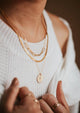 Layered 14kt Gold FIll necklaces featuring a custom hand-stamped necklace with a flora bouquet.