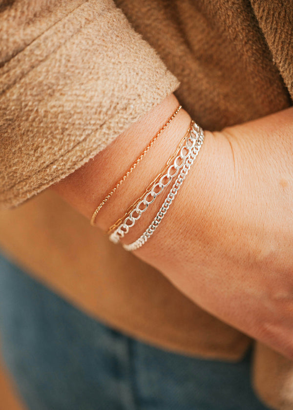 Layered bracelets in Sterling Silver and 14kt Gold Fill featuring a unisex flat curb chain bracelet.