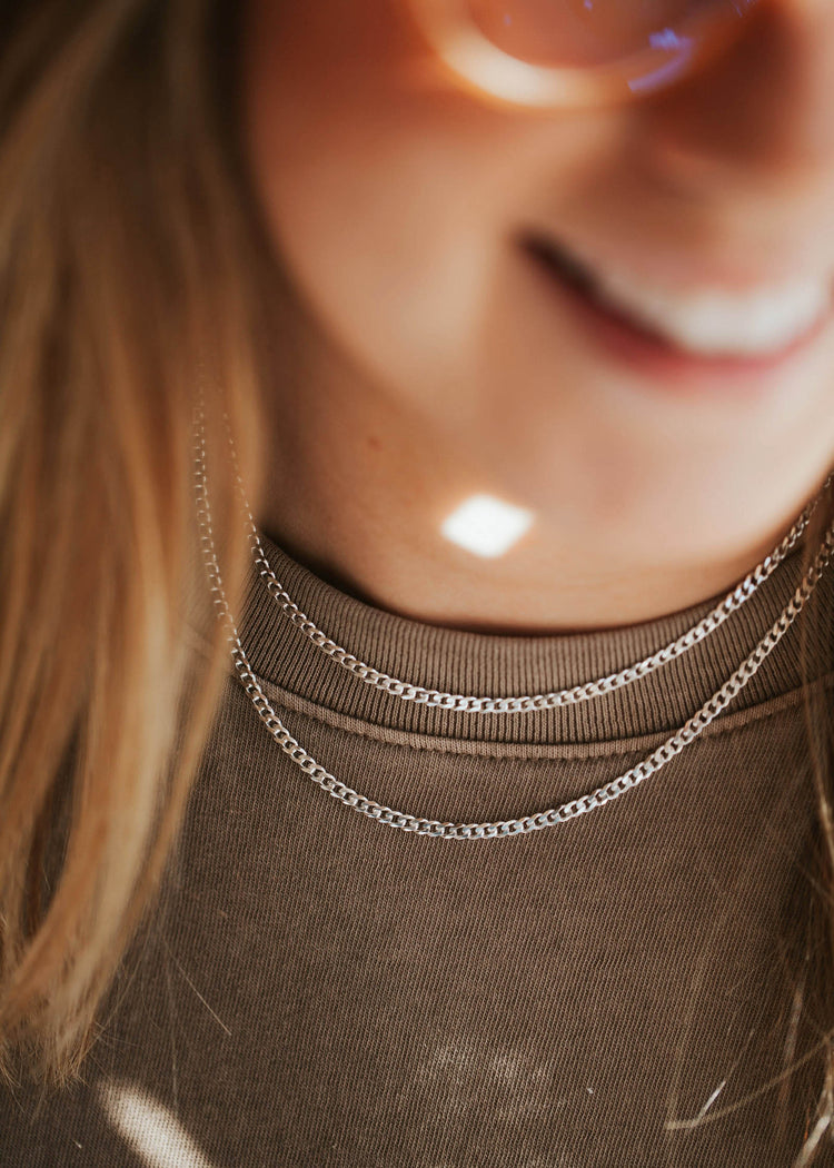 Diamond-cut flat curb chain layered necklaces on a young woman in Sterling Silver.