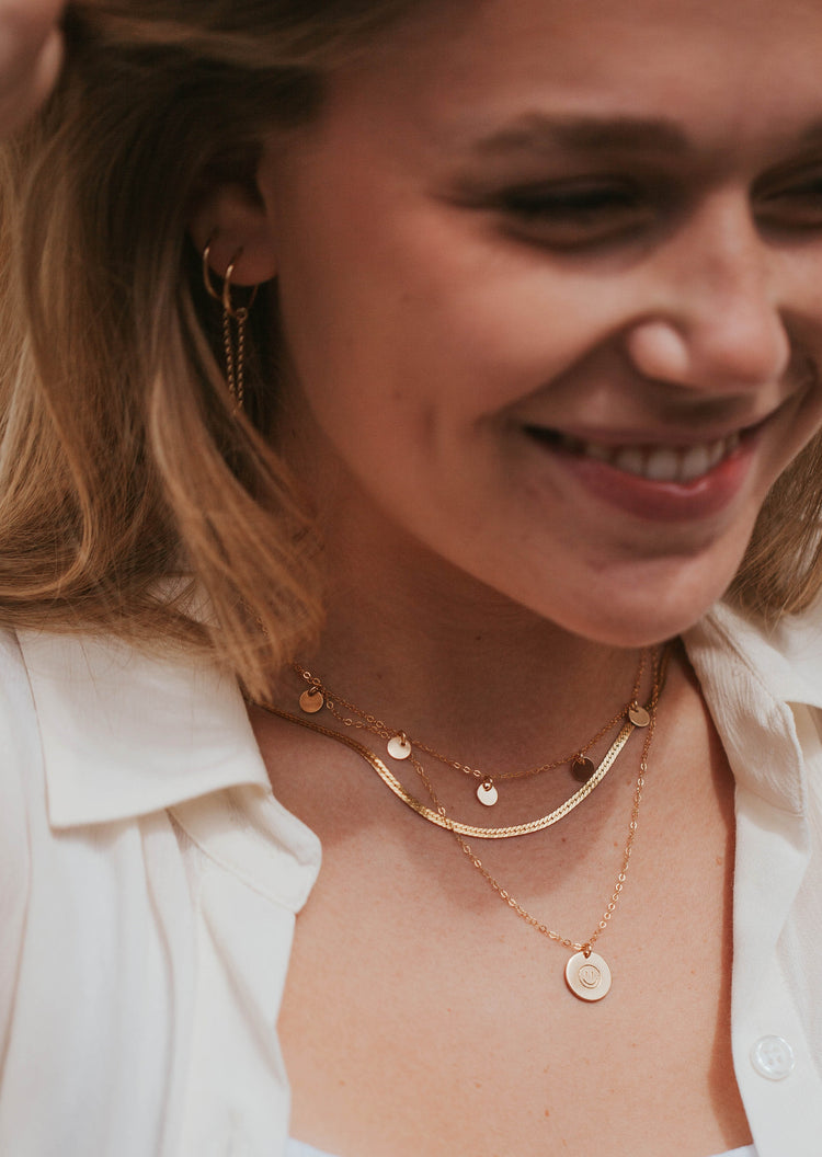 Young girl wearing stacked 14kt Gold Fill necklaces featuring a Smiley Face Necklace