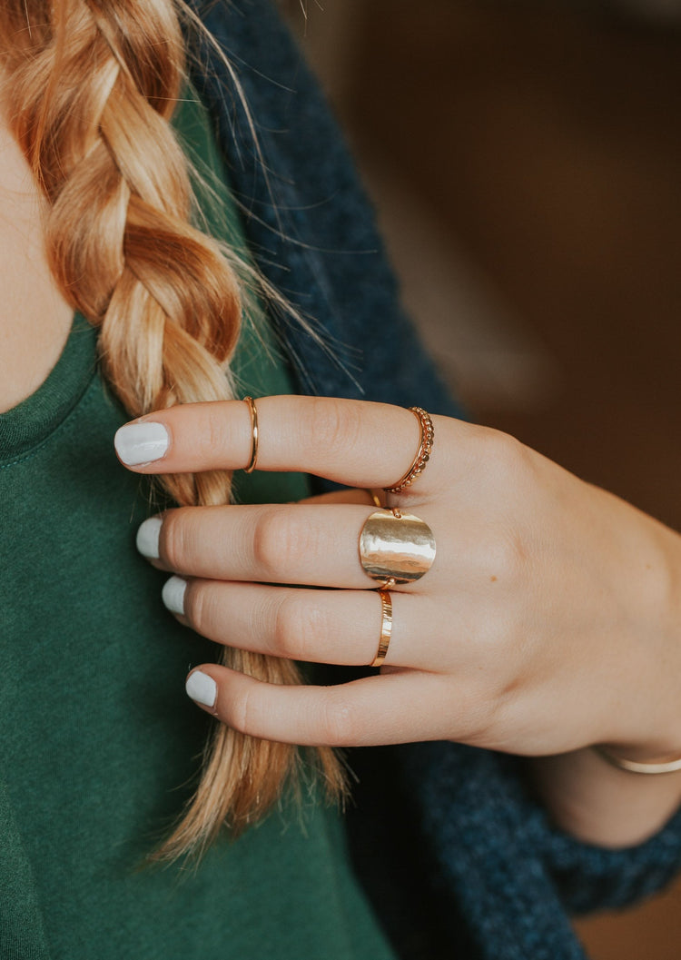Wondering how to stack rings on fingers? Hello Adorn created this gold ring stack using stacking rings and a statement ring with an above the knuckle ring, flat ring, hammered ring in Confetti Ring style, thin ring, and a circle ring hammered to look like a moon ring.