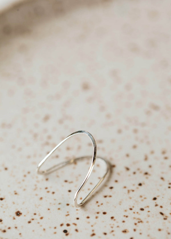 A sterling silver ring in the Swell Ring style handmade by Hello Adorn by taking a wire ring and turning it into a wave ring.