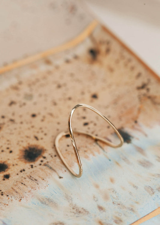 A wire ring hand-shaped and hammered to create a wave ring to use as a statement ring by Hello Adorn.