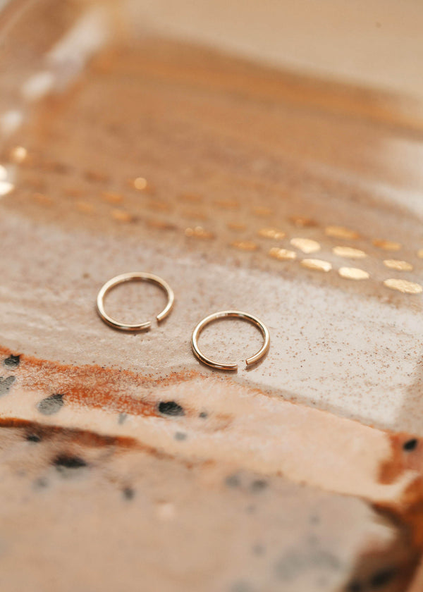 Gold hoop earring laying flat by Hello Adorn great for minimalist jewelry.