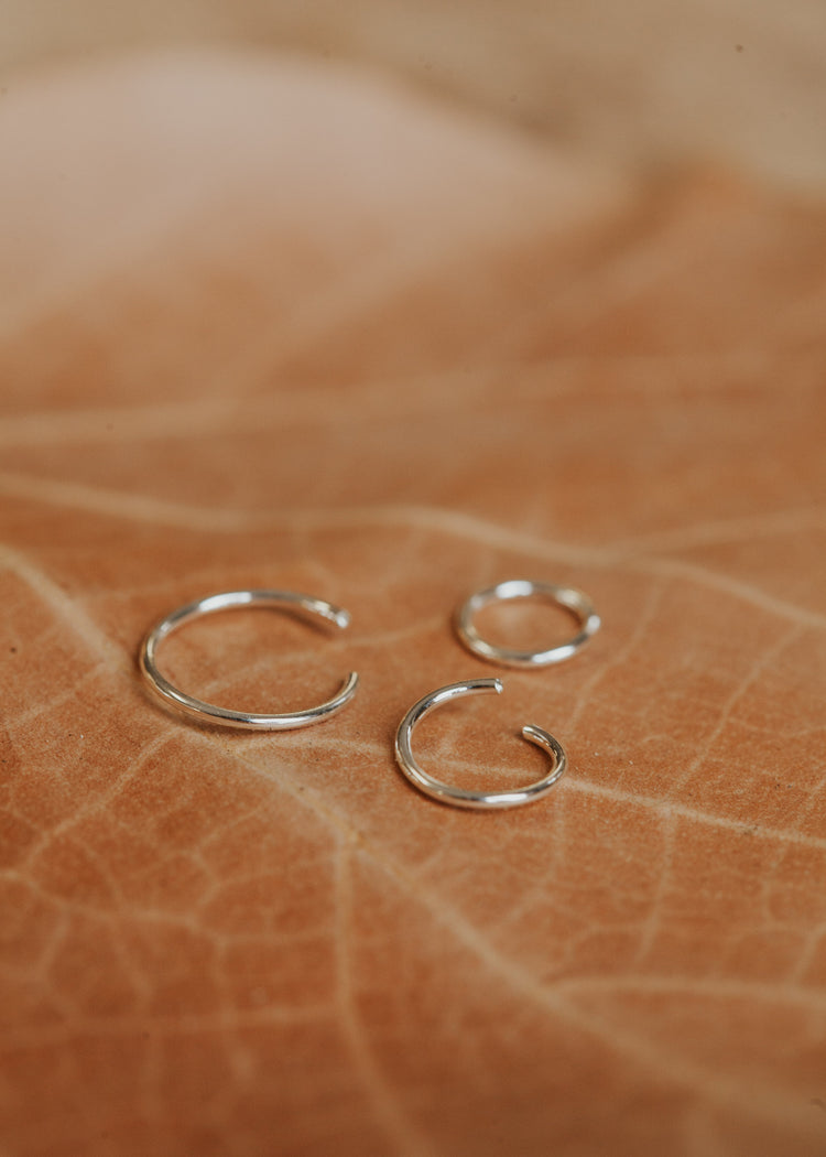 Sterling silver hoop earring shown in three sizes of 5MM, 7MM, and 9MM by Hello Adorn.