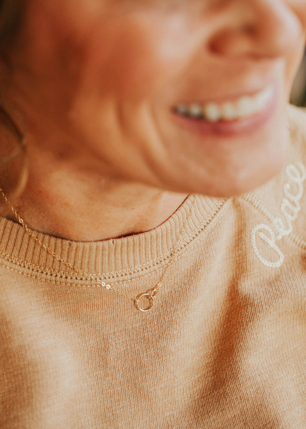 Model wearing a gold interlocking circle necklace by Hello Adorn.